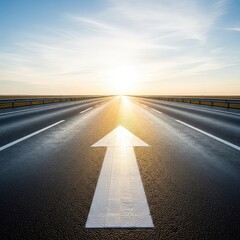 Obraz premium A wide asphalt road stretches toward a distant horizon under a bright sky, featuring a white painted arrow pointing forward on the pavement, sky, direction, arrow