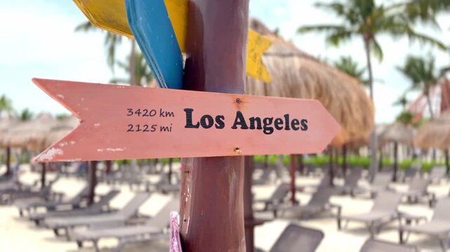 Los angeles distance signpost on tropical beach vacation destination