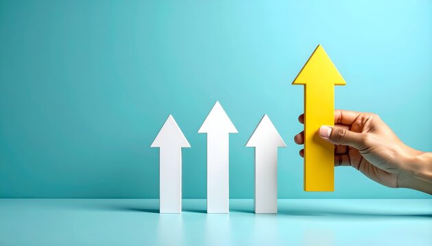 Business growth and leadership concept with a hand holding a large yellow upward arrow beside white arrows, symbolizing progress, innovation, achievement, and choosing a successful direction.