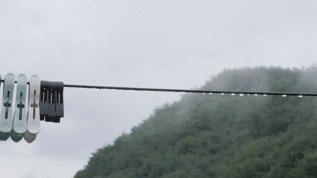 Raindrops Hanging on Clothesline in Rural Mountains on a Rainy Day