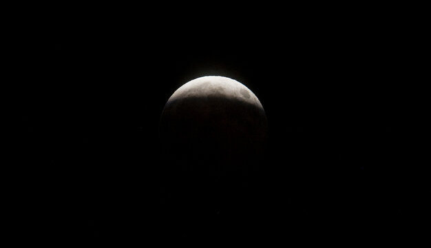 Partial lunar eclipse showing the moon partially obscured by Earth's shadow