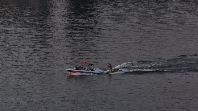 Aerial of water recreation on Tennessee River in Chattanooga at sunset with a motorized boat and a person wakeboarding