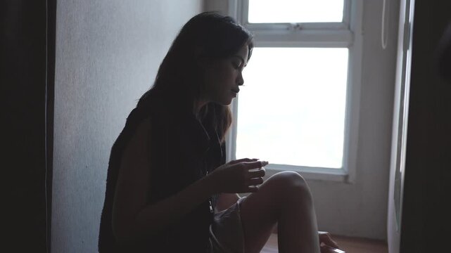 Silhouette of a young asian woman applying face powder
