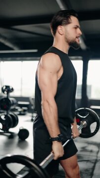 Dedicated muscular man with beard performing intense barbell front squats in a modern fitness center, building strength and muscle mass during a challenging weightlifting workout session