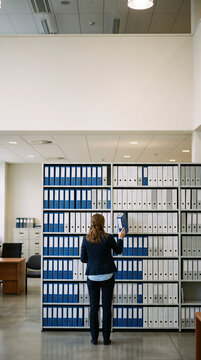 Businesswoman organizing files in a modern office archive