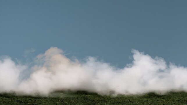 Thick white mist rolling across a green grass field, creating a mysterious and ethereal atmosphere with expansive copy space for design