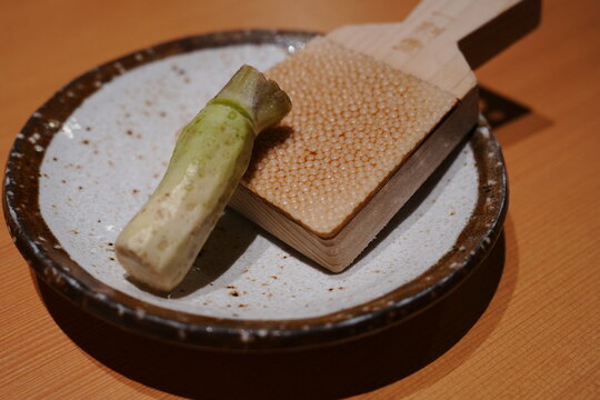 Fresh raw wasabi root with a traditional wasabi grater on wooden table - 日本料理 新鮮な生の本わさび おろし板
