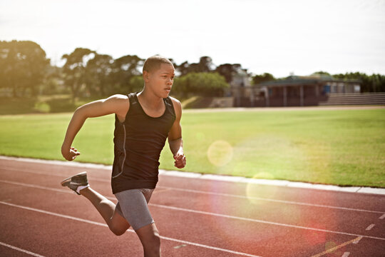 Teenager, boy and running on track with exercise, cardio training and practice for school athletics. Student, athlete and runner outdoor with speed workout, sprint and fitness at sports academy.