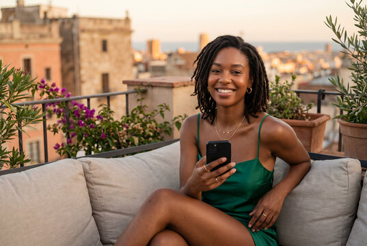 Young African American woman smiling on rooftop terrace at sunset