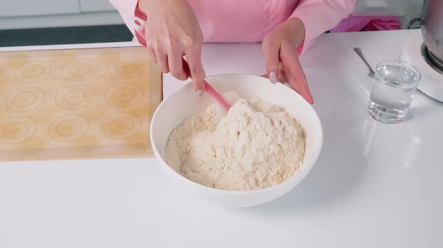 Mixing flour and dry ingredients in a bowl during baking preparation