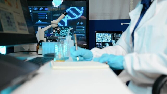 Asian female scientist examines a chemical flask and takes notes in a futuristic laboratory. She analyzes DNA sequencing data