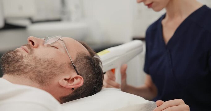 Laser hair growth activator for men in medical clinic, androgenetic alopecia concept.