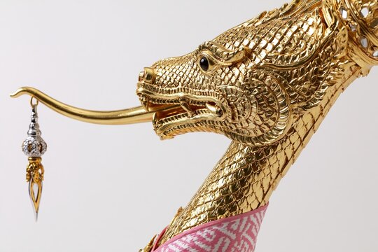 Golden mythical serpent statue head with decorative ornament