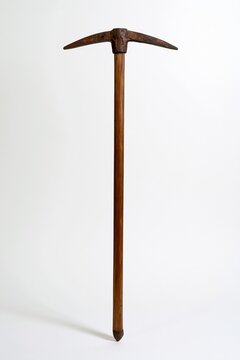 rusty pickaxe with wooden handle standing upright