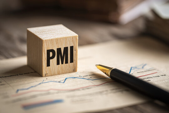 Text PMI on wood cube and  pen lay on chart candle document paper , economic data concept 