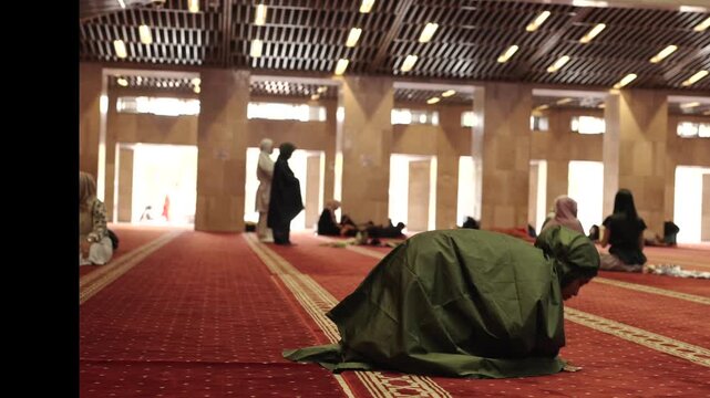 Muslim woman performing daily prayer inside mosque