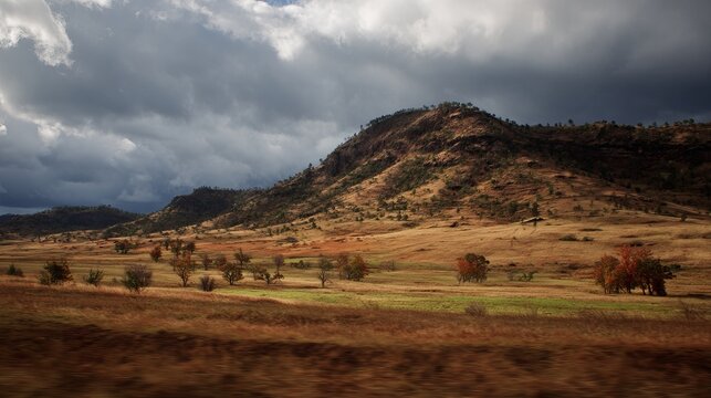 Dramatic Landscape - Rolling Hills Under a Stormy Sky in Rural Setting.