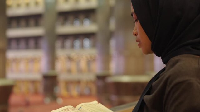 Muslim woman reading the quran in a grand mosque