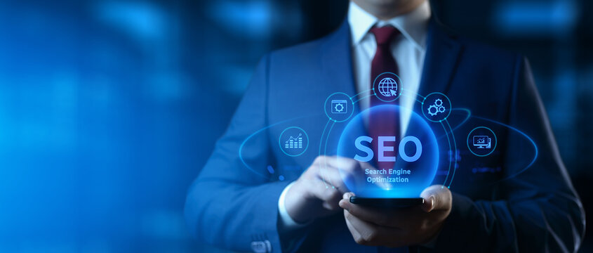 Businessman holding smartphone with Search Engine Optimization SEO icons on screen - Digital Marketing Concept