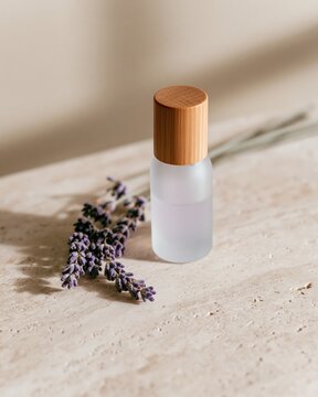 Small frosted cosmetic bottle with lavender on stone table