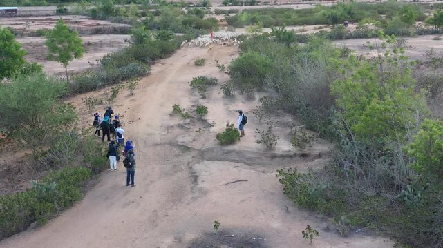 Aerial drone view of photographers capturing Cham women in traditional dress herding sheep in An Hoa Village, Xuan Hai, Khanh Hoa, Vietnam, showcasing rural life and cultural heritage.