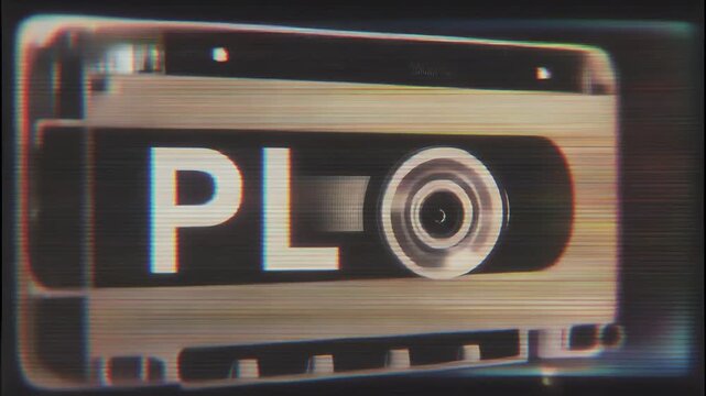 Close-up shot of a VHS tape with 'PLO' label and reel visible.
