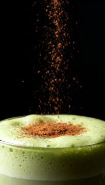 cinnamon powder falling over matcha horchata foam in clear glass for gourmet beverage commercial advertising poster template and product packaging display presentation