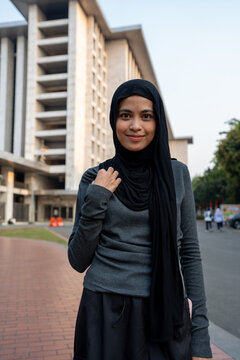 Muslim woman smiling wearing hijab outside mosque
