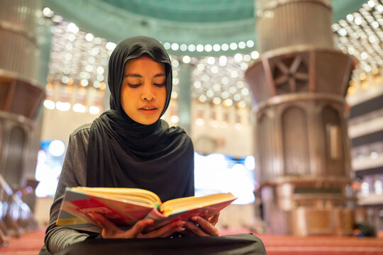 Muslim woman reading quran in mosque
