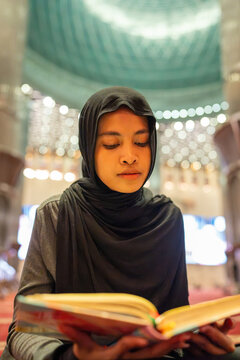 Muslim woman reading quran in a mosque