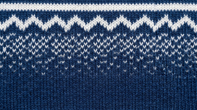Close up of a dark blue knitted sweater with a textured nordic pattern