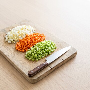 Overhead chopping board with diced onion carrot and celery