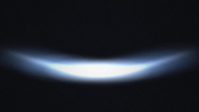 Abstract glowing blue arc light effect with film grain texture on a dark black background
