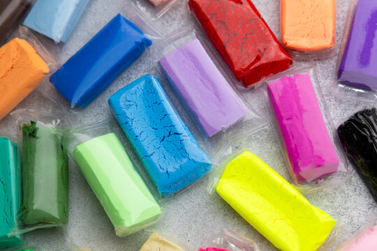 Variety of air dry modeling clay in bright colors placed on a flat surface