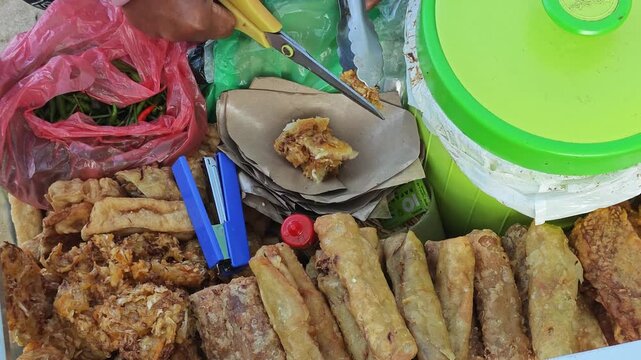 Street Vendor Cutting Indonesian Gorengan Fried Snacks with Scissors