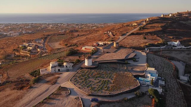 Drone aerial panoramic shot of row of traditional windmills on Gavrilos Hill ridge Emporio Santorini Greece