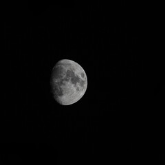 Fototapeta premium The moon before the full moon in the dark black sky