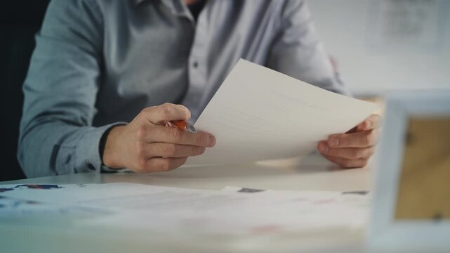 Male company CEO reads and signs business documents in office, doing paperwork