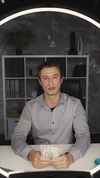 POV of successful financial coach in his 30s recording video blog on cellphone