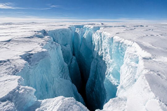 Deep glacier crevasse with blue ice walls in polar landscape, glacial environment and climate concept