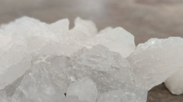 Natural white alum crystal stones on a textured concrete surface. Ideal for natural deodorant, body care, cosmetics, and water purification concepts