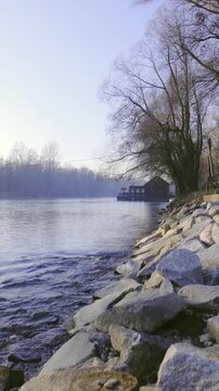 Moving over rocks above river with mill in background