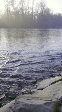 Camera moving over rocky bank with river flowing