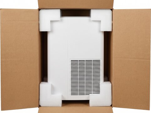 Top view of white home air purifier packaged with foam corner protectors inside open cardboard shipping box for home appliance delivery and retail unboxing