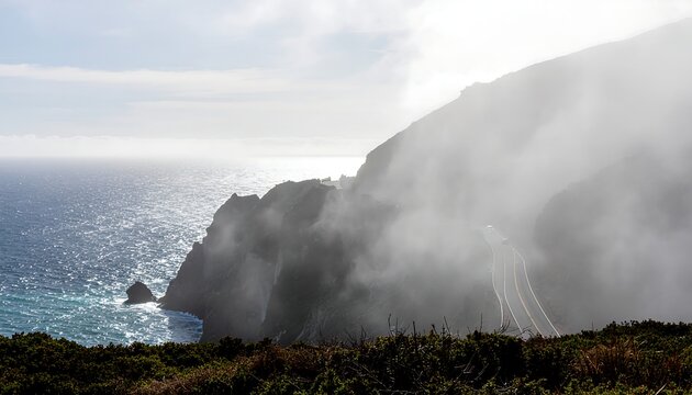 Misty coastal cliffs with ocean view and fog rolling over landscape