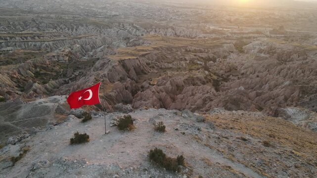 Cinematic aerial drone footage of Cappadocia&rsquo;s spectacular rock formations and fairy chimneys at sunset, bathed in warm golden light, showcasing the unique volcanic landscape of central Turkey.