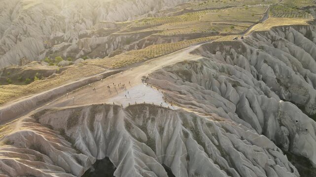 Cinematic aerial drone footage of Cappadocia&rsquo;s spectacular rock formations and fairy chimneys at sunset, bathed in warm golden light, showcasing the unique volcanic landscape of central Turkey.