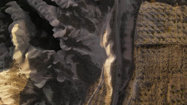 Cinematic aerial drone footage of Cappadocia&rsquo;s spectacular rock formations and fairy chimneys at sunset, bathed in warm golden light, showcasing the unique volcanic landscape of central Turkey.