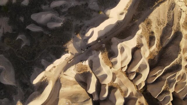 Cinematic aerial drone footage of Cappadocia&rsquo;s spectacular rock formations and fairy chimneys at sunset, bathed in warm golden light, showcasing the unique volcanic landscape of central Turkey.