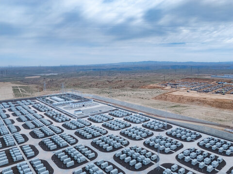 Large outdoor energy storage station with neatly arranged battery arrays under cloudy sky